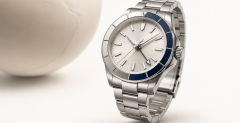 GMT watch with a 24-hour hand and rotating bezel beside a travel map